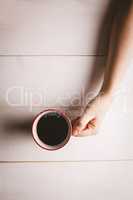Womans hand holding coffee cup