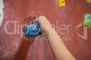 Boy practicing rock climbing in fitness studio