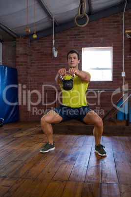 Determined man exercising with kettlebell