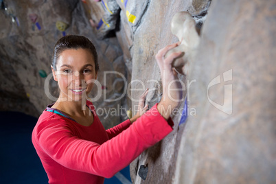 Portrait of confident woman practicing rock climbing