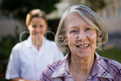 Portrait of senior woman with doctor at park