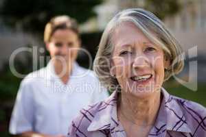 Portrait of senior woman with doctor at park