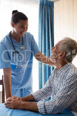 Female doctor consoling senior man in retirement home
