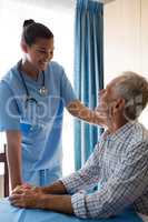 Female doctor consoling senior man in retirement home