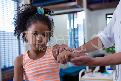 Physiotherapist giving hand massage to a girl