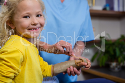 Female physiotherapist giving hand massage to girl patient