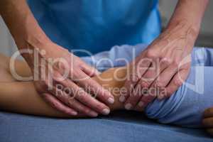 Physiotherapist giving leg massage to patient