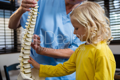 Physiotherapist explaining the spine to girl patient