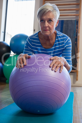 Senior woman in performing exercise on fitness ball