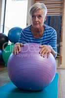 Senior woman in performing exercise on fitness ball