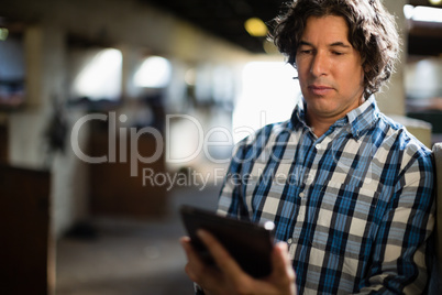 Man using digital tablet in the stable