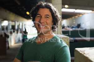 Happy man standing in the stable