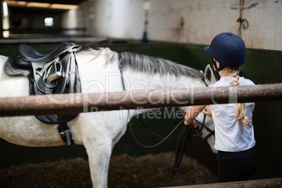 Teenage girl standing with horse