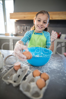 Smiling girl picking up eggs