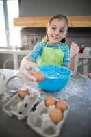 Smiling girl picking up eggs