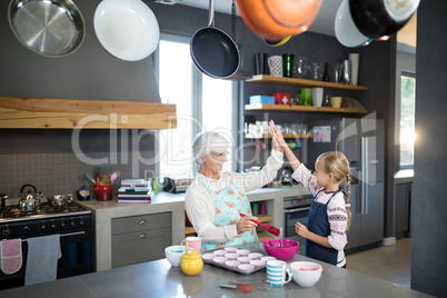 Smiling grandmother and granddaughter giving a high five