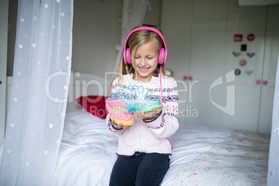 Little girl playing with spring toy with headphones