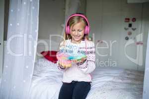 Little girl playing with spring toy with headphones