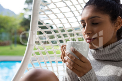 Woman holding coffee cup in swing chair