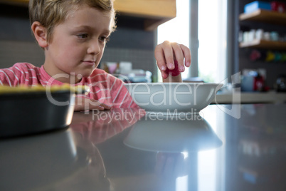 Boy having food in kitchen