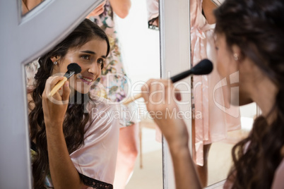 Bride applying her makeup doing her wedding preparation