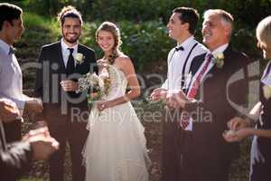 Portrait of bride and groom standing with guests