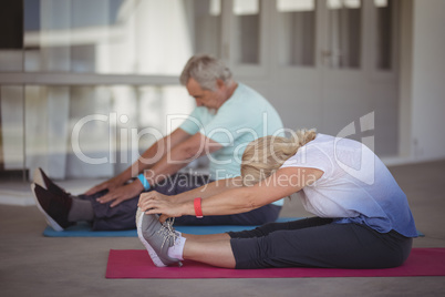 Senior couple performing stretching exercise