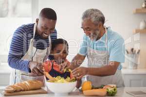 Multi-generation family preparing food in kitchen