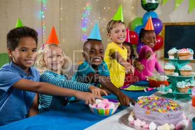 Portrait of children pointing on cake