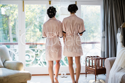 Rear view of women standing near window
