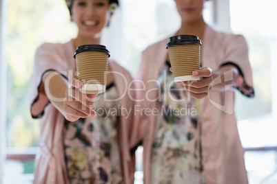 Portrait of smiling woman showing a cup of coffee