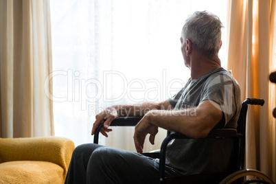 Senior man looking away while sitting on wheelchair