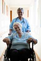 Portrait of nurse pushing patient sitting in wheelchair