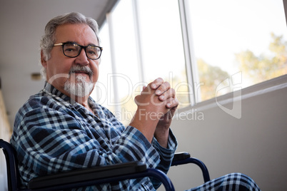 Portrait of senior man sitting on wheelchair in retirement home