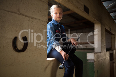 Girl sitting in stable