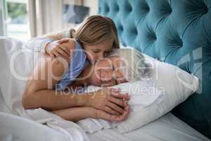 Granddaughter kissing her grandmother on bed