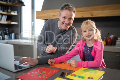 Father and daughter posing while coloring