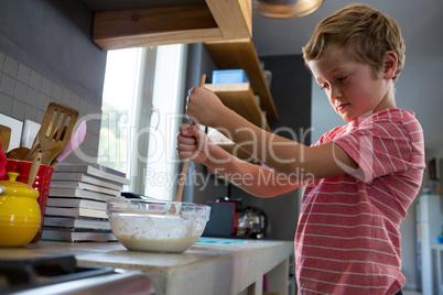 Boy mixing batter in kitchen