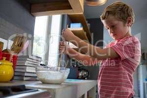 Boy mixing batter in kitchen