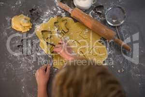 Cropped image of boy making shapes from cookie cutter