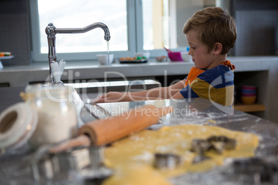 Boy washing hands in kitchen