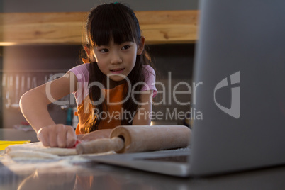 Girl looking into laptop in kitchen