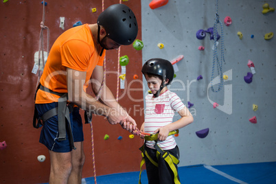 Trainer assisting boy to wear safety harness