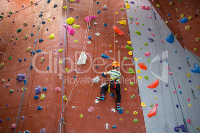 Boy practicing rock climbing in fitness studio