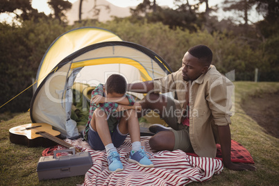 Father comforting his son in park