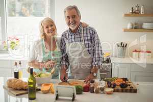 Senior couple preparing meal in kitchen