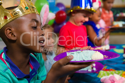 Close up of boy looking at cake in plate