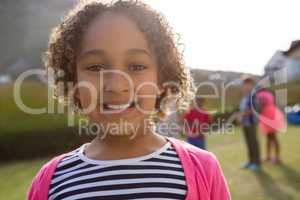 Portrait of smiling girl with friends playing in background