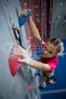 Determined teenage girl practicing rock climbing