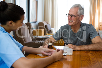 Senior man talking to female doctor in nursing home